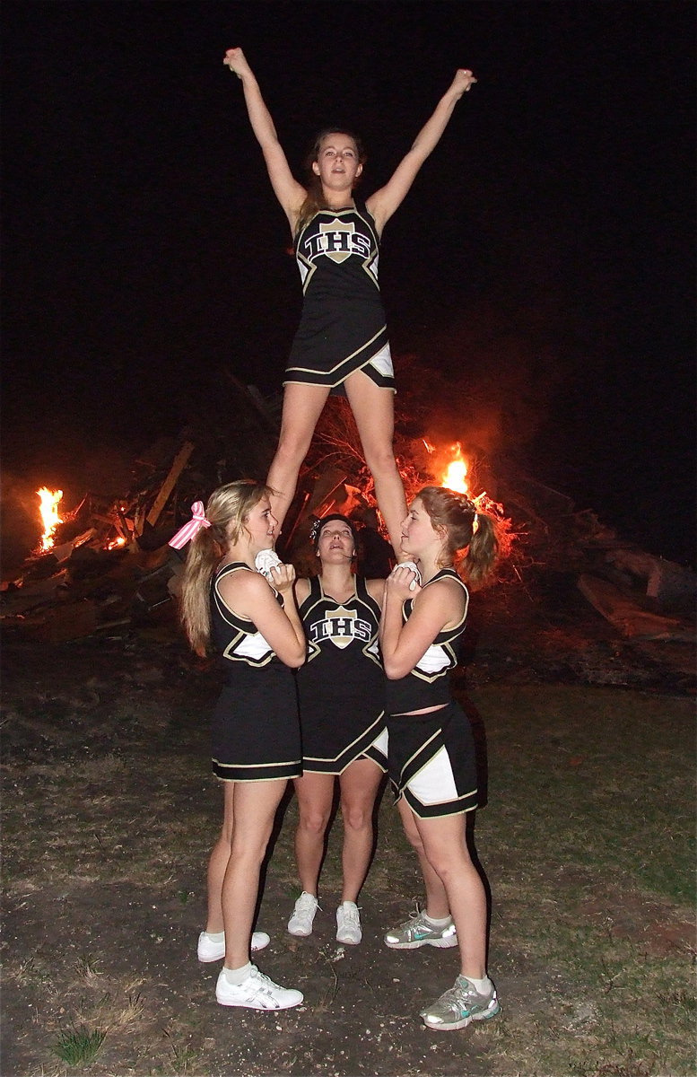 Image: IHS cheerleaders Kelsey Nelson, Taylor Turner, Morgan Cockerham and Britney Chambers perform a stunt as the bonfire and crowd begin to roar. Go Italy!