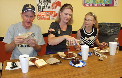 Image: Randy Boyd, his wife Becky and daughter Taylor are thoroughly enjoying the meal while their son Cody Boyd, a sophomore member of the Italy Gladiators football team, gets ready to play the Cross Roads Bobcats for homecoming.