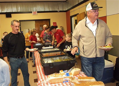 Image: Kyle Holley and Mark Stiles storm the chow line with bar-b-que and link sausage links as the main course.