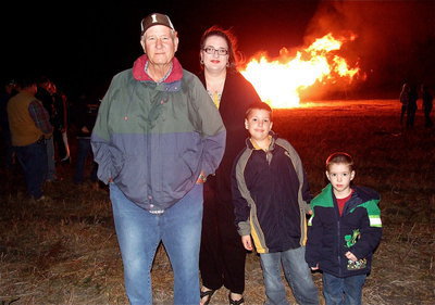 Image: Richard Cook and his daughter Amy and her two sons enjoy having family time while watching the bonfire.