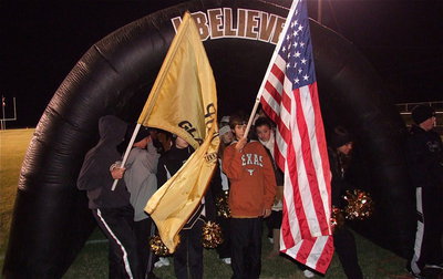 Image: Ty Hamilton and Clay Riddle believe as they prepare to hand the flags over to the team while the IHS cheerleaders seek warmth inside the tunnel on a chilly night for Texas football.