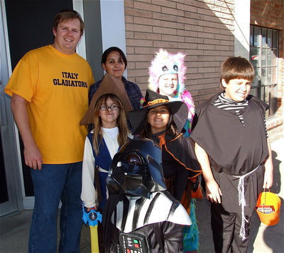 Image: Mike and Tessa South trick-or-treat along main street in Italy with their a scary group of kids: Captain Catie, Eva Eerie Witch, Frank Vader, Mikey as I-gore and a colorful Sydney Lowenthal in the back row dressed as a Scare-Bear.