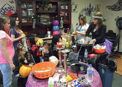 Image: Deonna Padilla greets trick-or-treaters as they enter Bling-n-Blooms for snacks, hotdogs, nachos and punch.