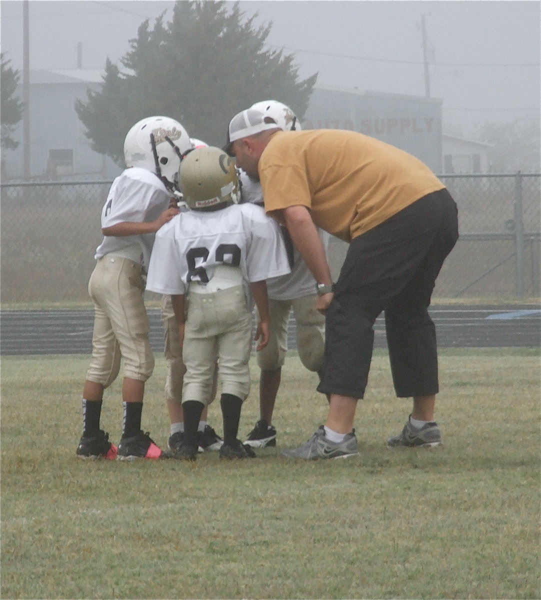 Image: IYAA C-team coach Mark Souder, Jr., tells a top secret play to his backfield during their playoff game against Blooming Grove.