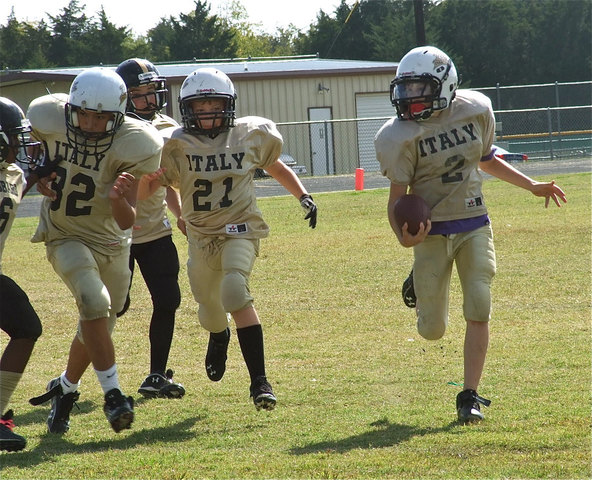 Image: A-team Gladiators Jonathan Sals(82) and Cade Brewer(21) block for Ryder Itson(2) who covers 42-yards for the first touchdown of their playoff game against Hubbard.