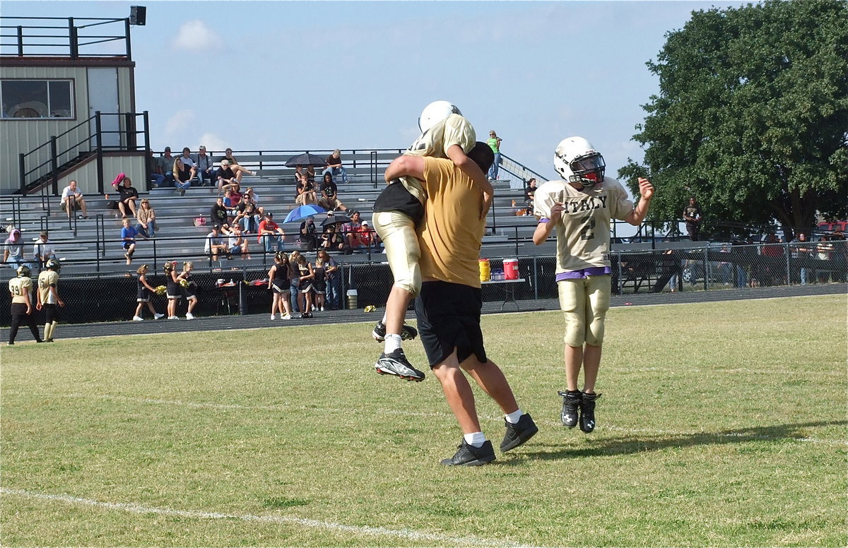 Image: A-team head coach, Aaron Itson rushes onto the field to congratulate his team as Jonathan Salas(82) leaps into his coach’s arms in celebration of a successful point-after kick by Salas.