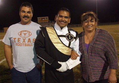 Image: Senior band member Yonatan (Jonathan) Davila is escorted by his parents, Sergio and Rosa Guiterrez. Yonatan plans to attend junior college and then transfer to a university to become an engineer.