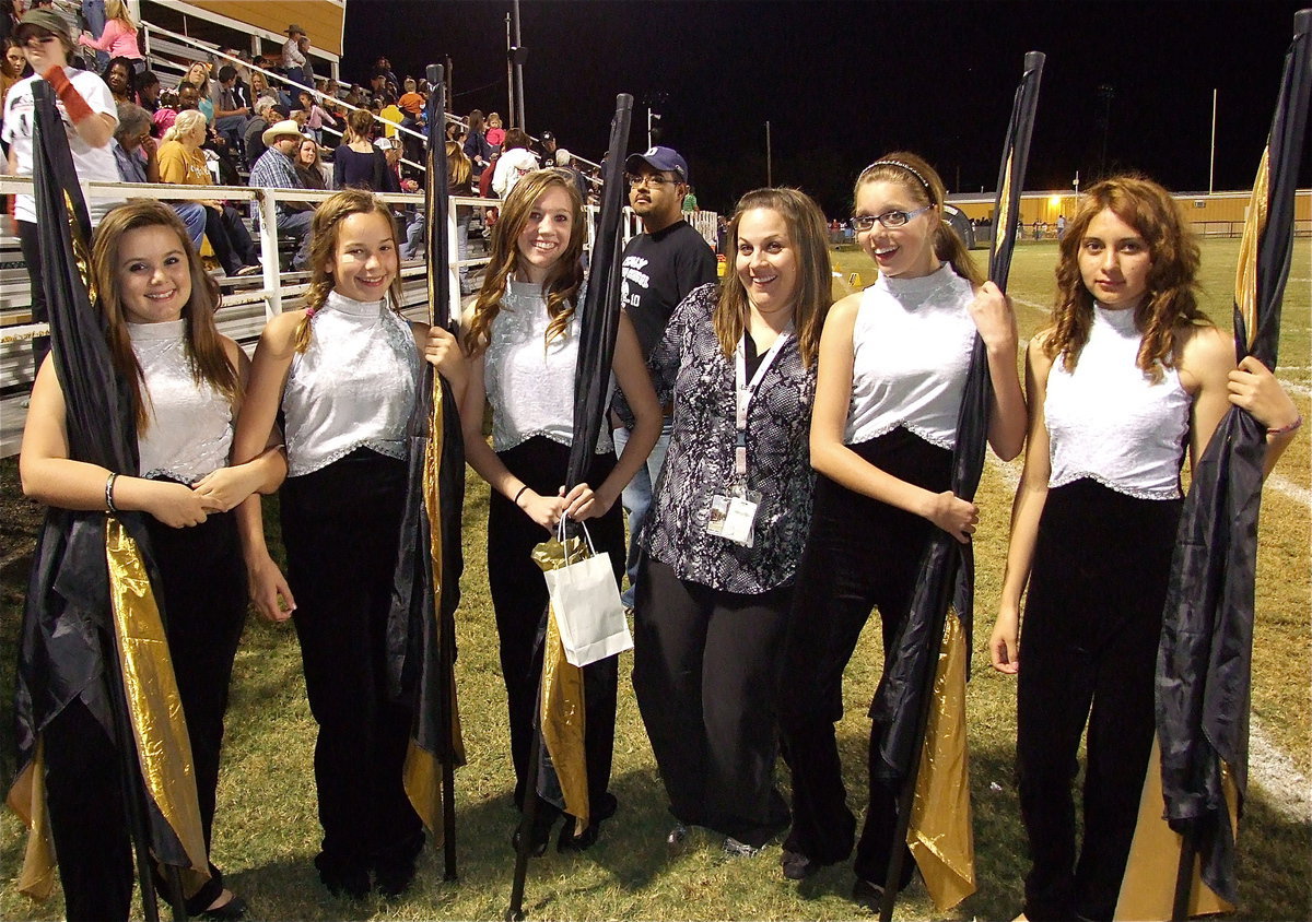 Image: Color guard director, Amber Droll poses with her color guard girls while band director Jesus Perez photo bombs the picture. Color guard members pictured are Alexis Burchett, Paige Little, Brooke Miller, Anna Riddle and Maria Patino. Not pictured is Ashlyn Jacinto.