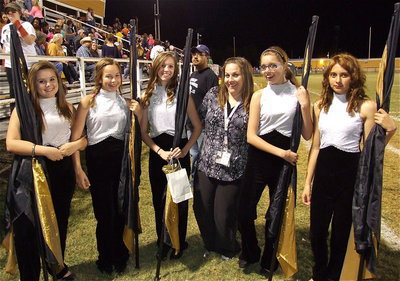 Image: Color guard director, Amber Droll poses with her color guard girls while band director Jesus Perez photo bombs the picture. Color guard members pictured are Alexis Burchett, Paige Little, Brooke Miller, Anna Riddle and Maria Patino. Not pictured is Ashlyn Jacinto.