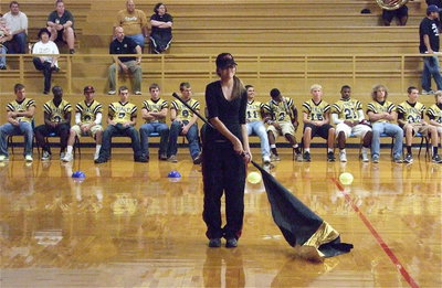 Image: Color guard member Anna Riddle works the flag during a routine performed at the pre-game pep-rally.