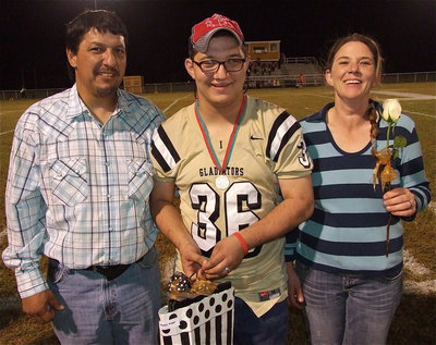 Image: 2012 Homecoming King Blake Vega wears the #36 jersey once worn by his brother, Justin Hayes, while being escorted by his parents, Carlos and Lavena Vega. Blake’s hobbies and interests include drinking Dr. Peppers and flirting with girls. His most memorable moment in athletics was winning medals at the Special Olympics and being crowned Homecoming King.