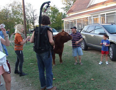 Image: “Director” Larry Eubank and granddaughter Ella Hudson shoot footage with the calf.