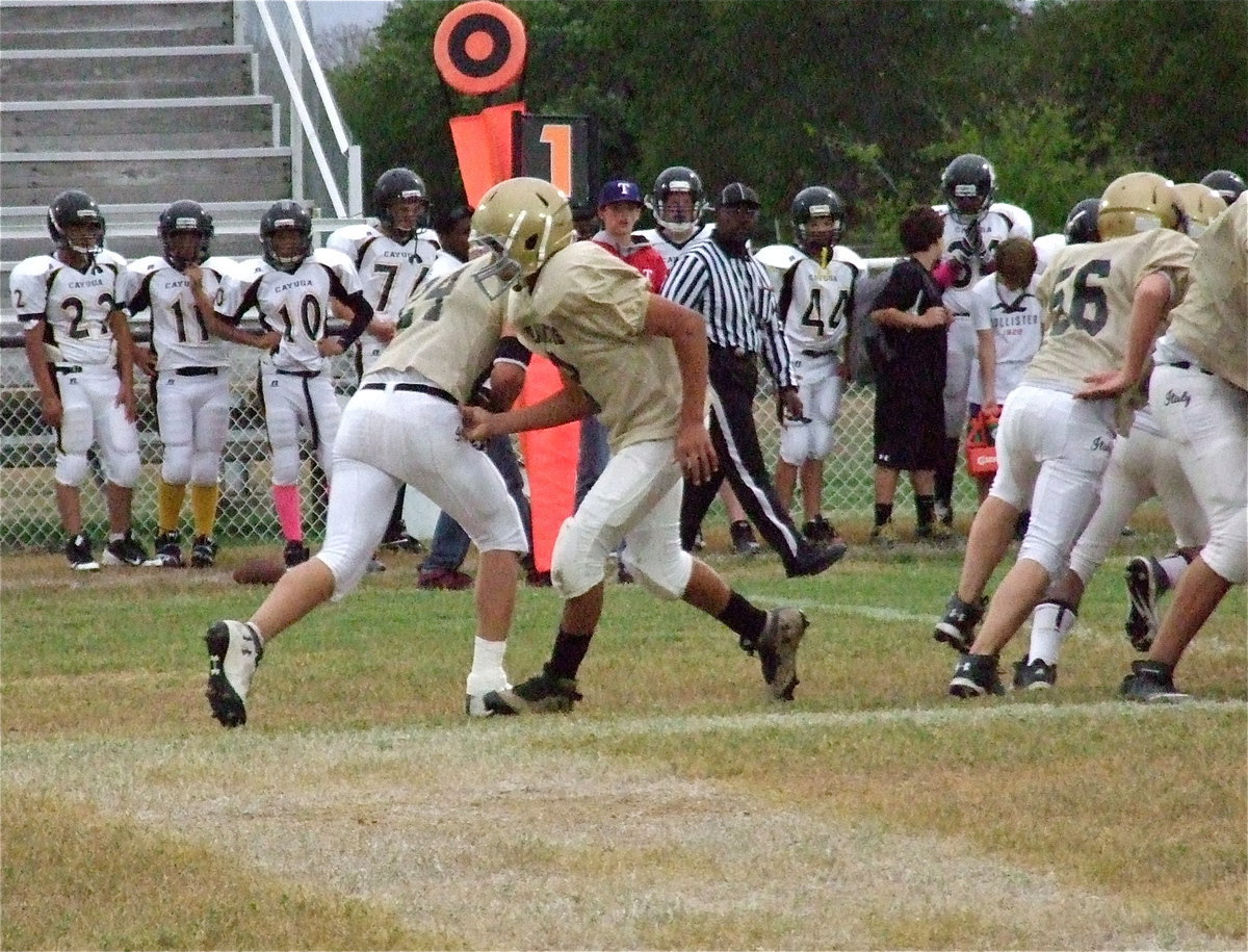 Image: Devonteh Williams(9) hands off to Joe Celis(24) who runs behind Elliott Worsham(56) and into the heart of the Cayuga defense.