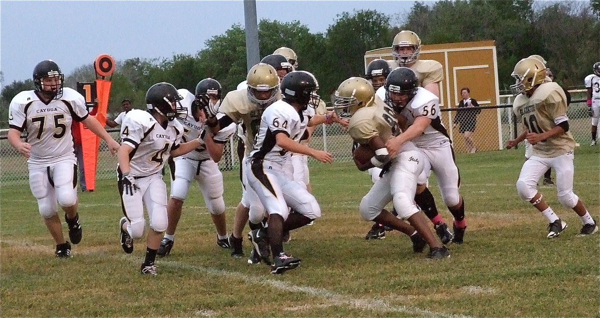 Image: Italy’s Jarvis Harris(89) fights to reach the Cayuga goal line as teammate Fabian Cortez(84) comes in to throw a block.