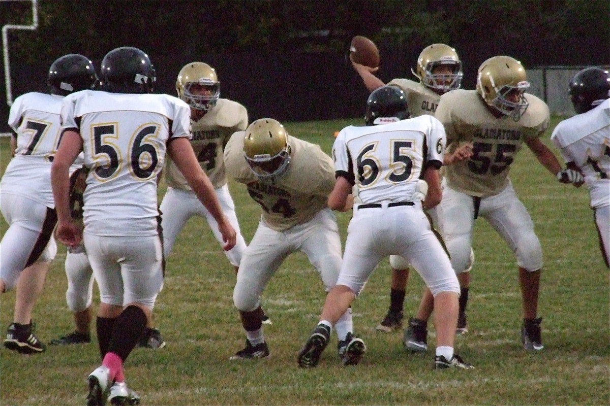 Image: Joe Celis(24), Kenneth Norwood, Jr.(54) and David De La Hoya(55) make a wall to keep Cayuga away from Devonteh Williams(9) as he locates a passing target.