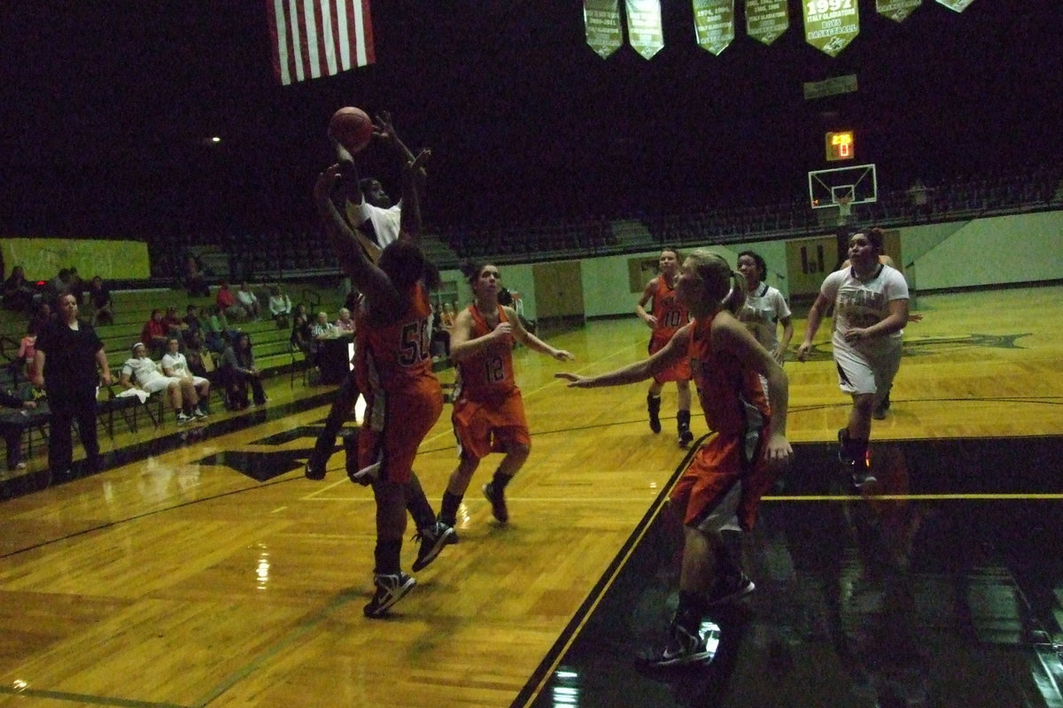 Image: Monserrat Figueroa(25) and Ryisha Copeland(11) charge to the hoop with teammate Kortnei Johnson(3) putting up the shot.