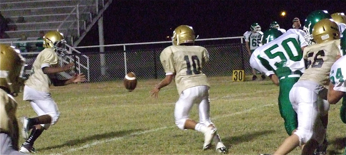 Image: Kendrick Norwood(20) takes the pitch from Tylan Wallace(10) as Elliott Worsham(56) throws a block.