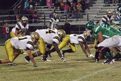 Image: Shad Newman(25), Reid Jacinto(11), Adrian Reed(64), Eric Carson(12), Jalarnce Jamal Lewis(65), Zain Byers(50) and Chase Hamilton(2) get set on defense against Kerens.