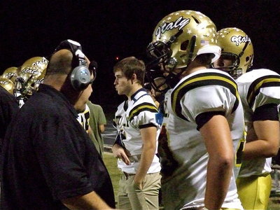 Image: Gladiator line coach Brain Coffman strategizes with two of his prize bulls, Zain Byers(50) and Kevin Roldan(60).