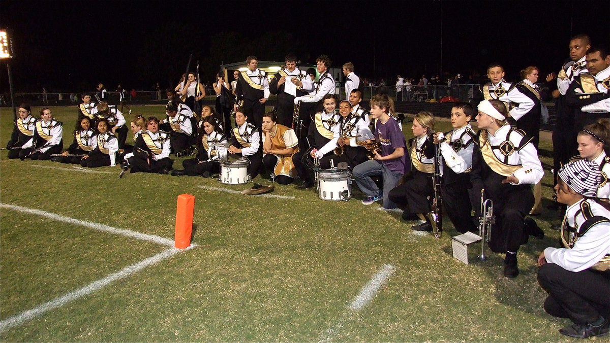 Image: The Gladiator Regiment Marching Band takes a knee as the Bobcat band performs during halftime.