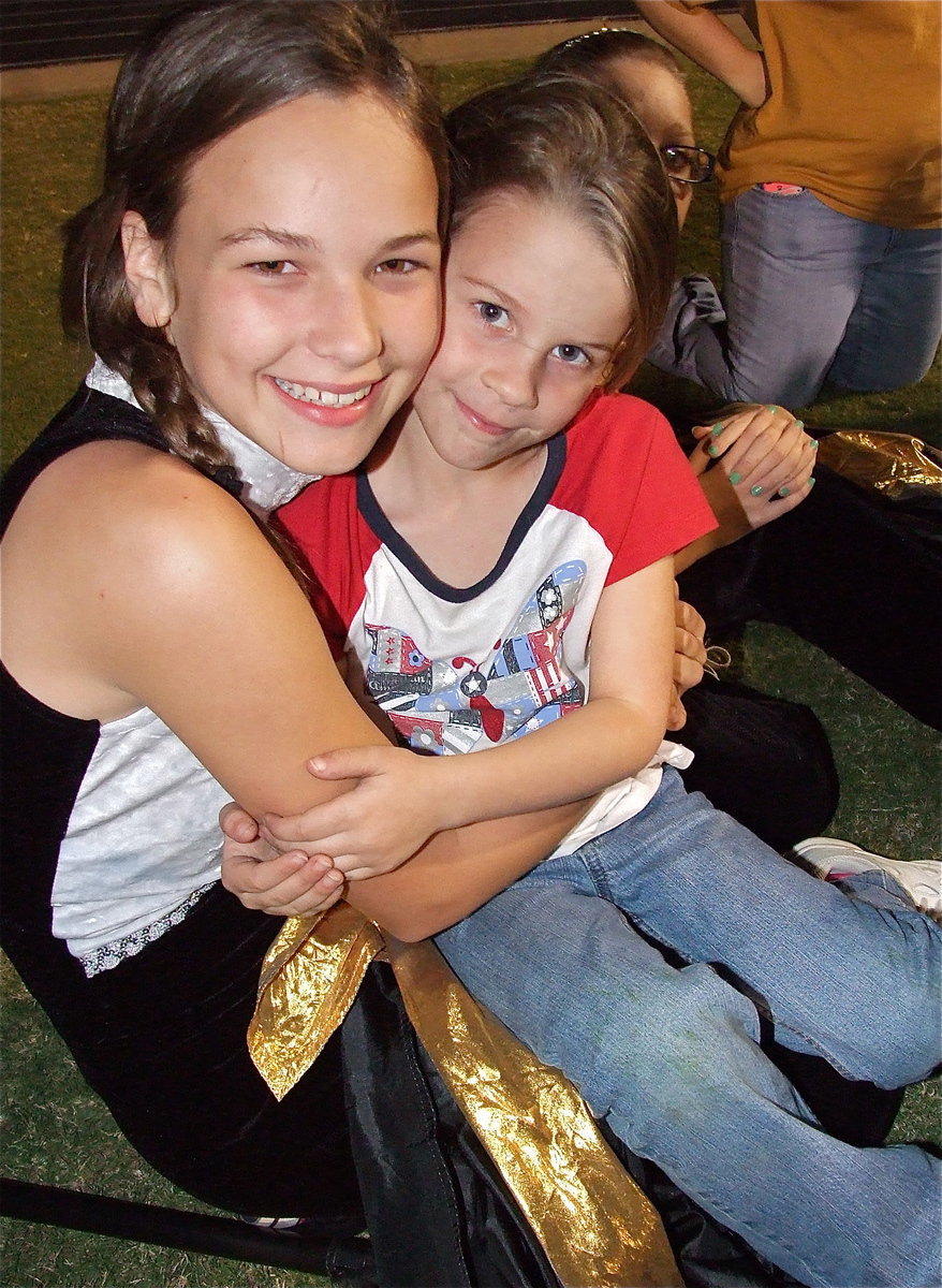 Image: Color-guard member Paige Little trades her flag for Mia Droll.