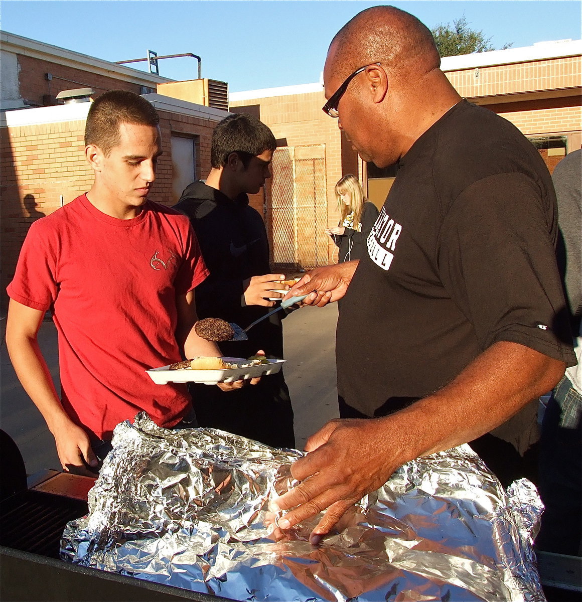 Image: Cody Medrano takes the patty from Coach Mayberry and runs with it to the condiments table.