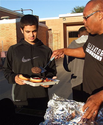 Image: Defensive tackle Reid Jacinto contains his food from spilling over as Coach Mayberry makes a move.