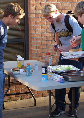 Image: Levi McBride, Cody Boyd and Clayton Miller strategize at the condiments table.