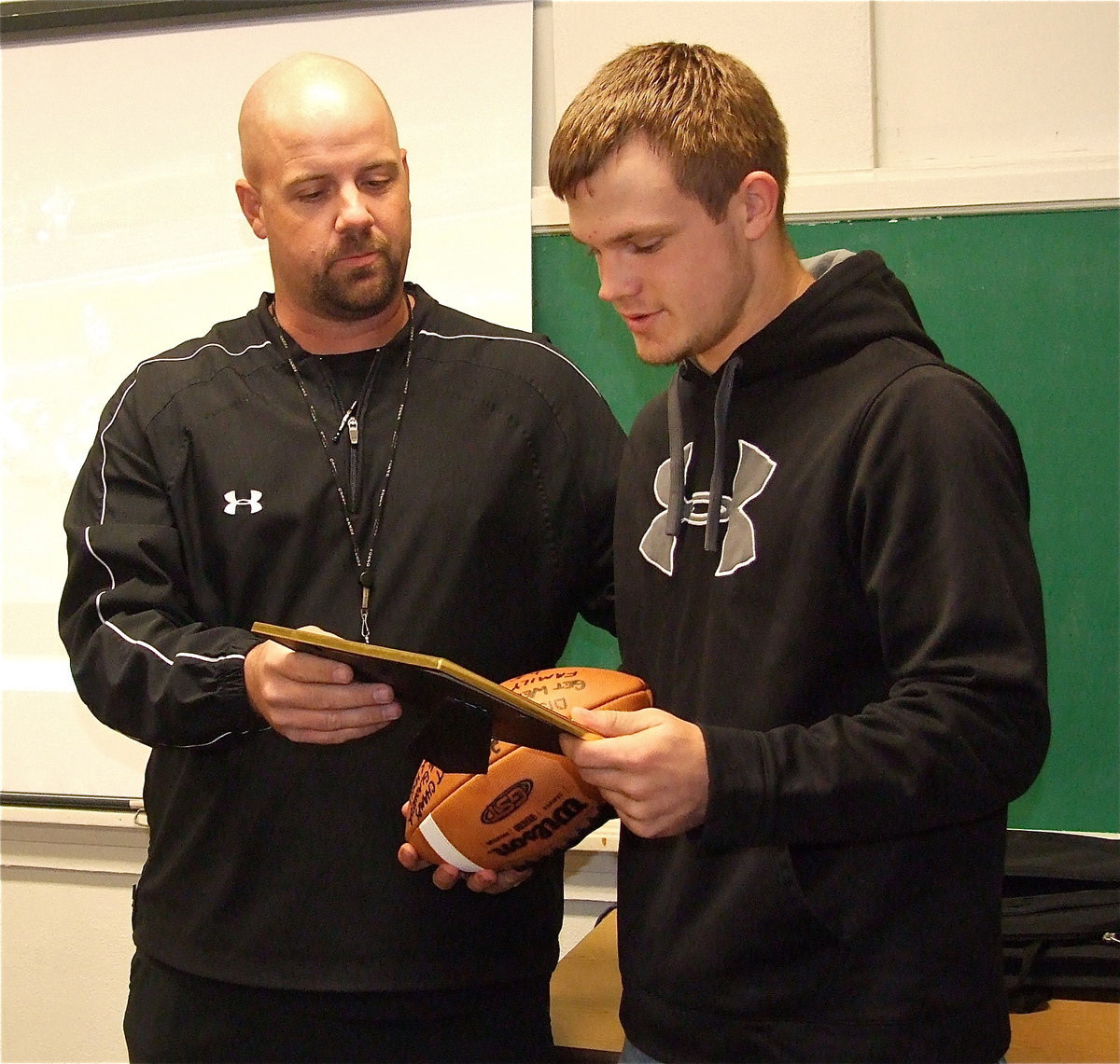 Image: Gladiator Football Head Coach/AD Hank Hollywood presented senior Chase Hamilton with a ball autographed by the team and a team photo of the team after the win over Kerens. A deflection by Chase helped cause an interception by Marvin Cox late in the game to seal the win over the Bobcats and help Italy claim the district crown. Chase displayed heart and courage while making it through the week of practices leading up to the Keren’s game while his father, Lee Hamilton, was in the hospital.