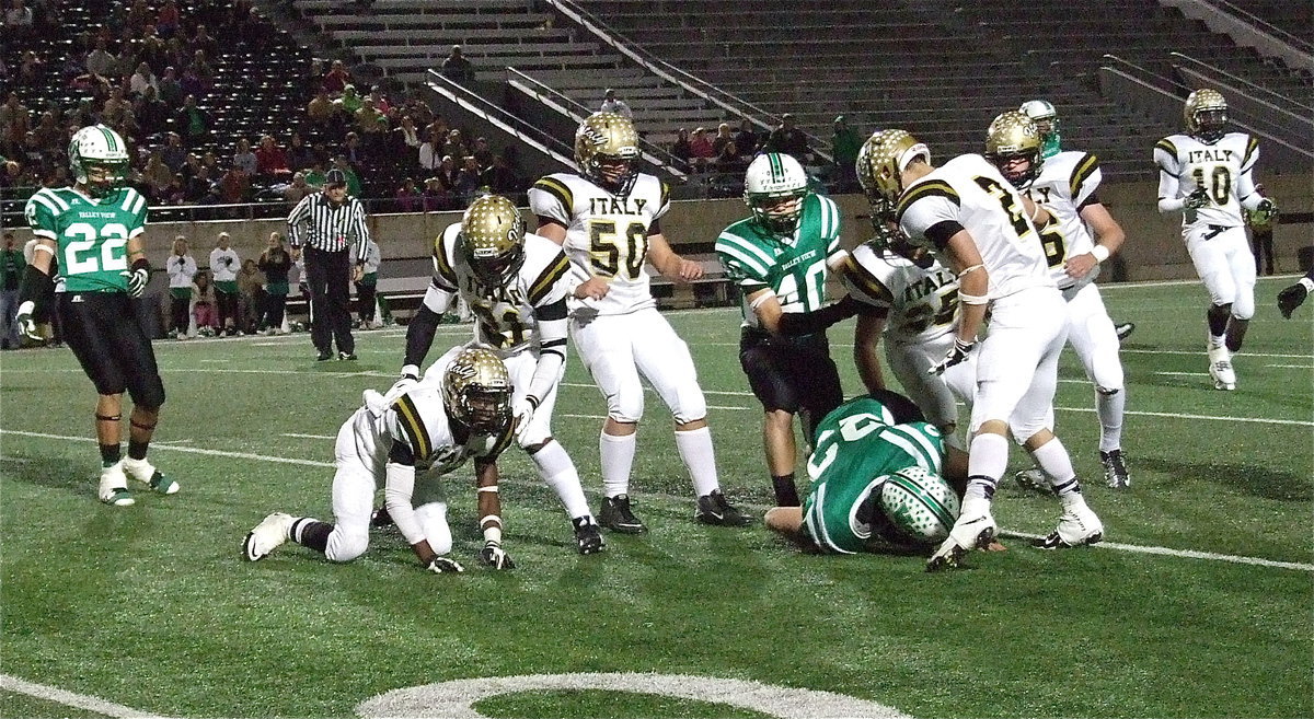 Image: Cornerback Eric Carson(12) upends Valley View’s top weapon as teammate Jalarnce Lewis(21) helps his teammate to his cleats. Carson finished the game with 13 tackles including 8 solos and 5 assists.