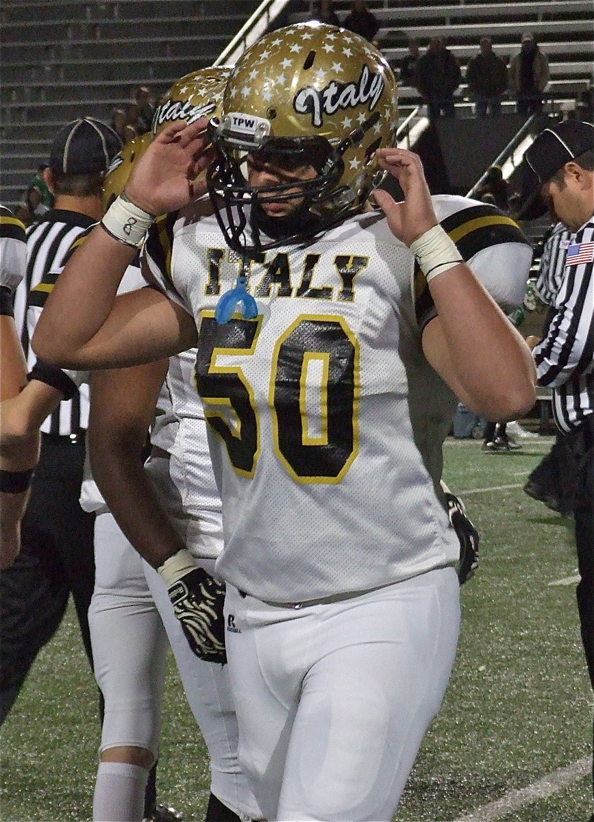 Image: Zain Byers(50) gets buckled up for battle against Valley View with jersey numbers of injured teammates written on his wrist tape for inspiration.