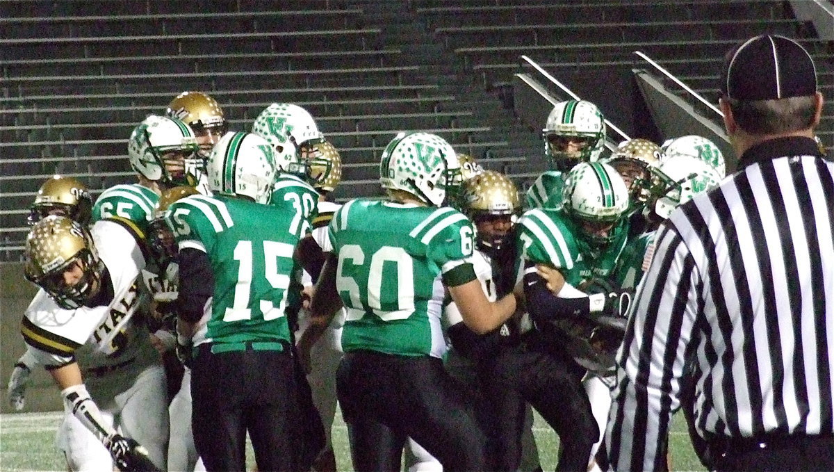 Image: Jalarnce Lewis(21) and Shad Newman(25) latch on to an Eagle runner, Cole Seese(7).