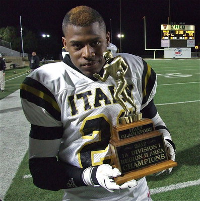 Image: Jalarnce Lewis(21) holds the area championship trophy with pride.