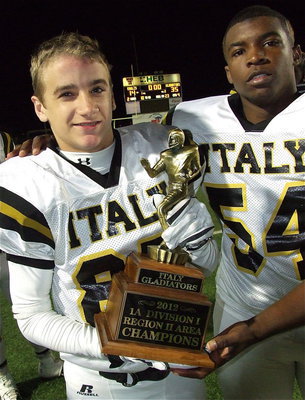Image: Levi McBride(85) and Justin Robbins(54) show off the area championship trophy claimed by the Gladiators after defeating Valley View in Bedford.
