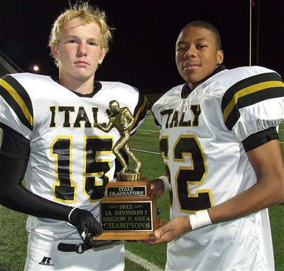 Image: Gladiators Cody Boyd(15) and John Hughes(62) stand with the area championship trophy after Italy’s victory.