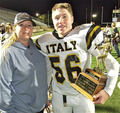 Image: Misty Escamilla with her Gladiator, John “J.T.” Escamilla(56), together with the area championship trophy.