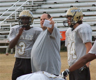 Image: Coach Brian Coffman instructs Marvin Cox and Hunter Merimon.