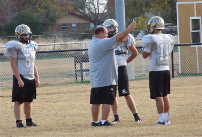 Image: Coach Brian Coffman talks technique with his defensive tackles.