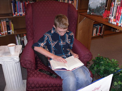 Image: Colton Allen, 7th grader, steadily reads his favorite book during the 8th Annual Read-A-Thon.