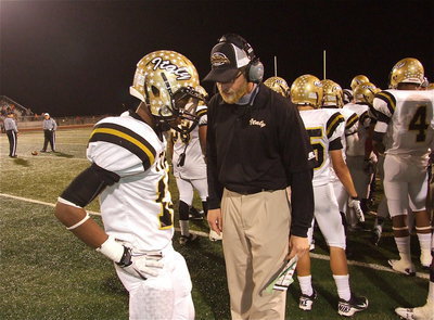 Image: Gladiator offensive coordinator Nate Skelton talks with receiver Eric Carson(12) during a timeout.