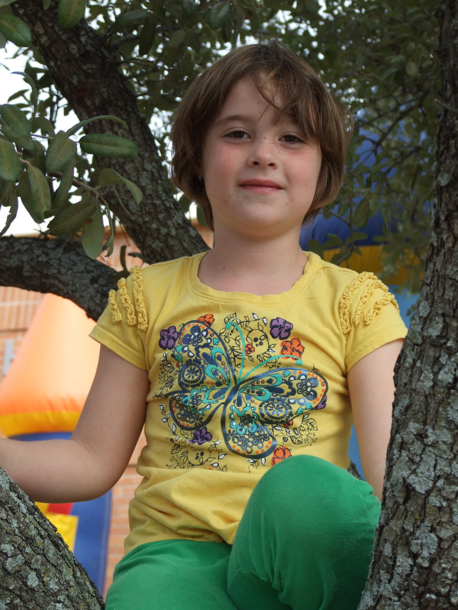 Image: Kathryn Dabney, age 5, enjoys climbing a nearby tree during the Thanksgiving feast.