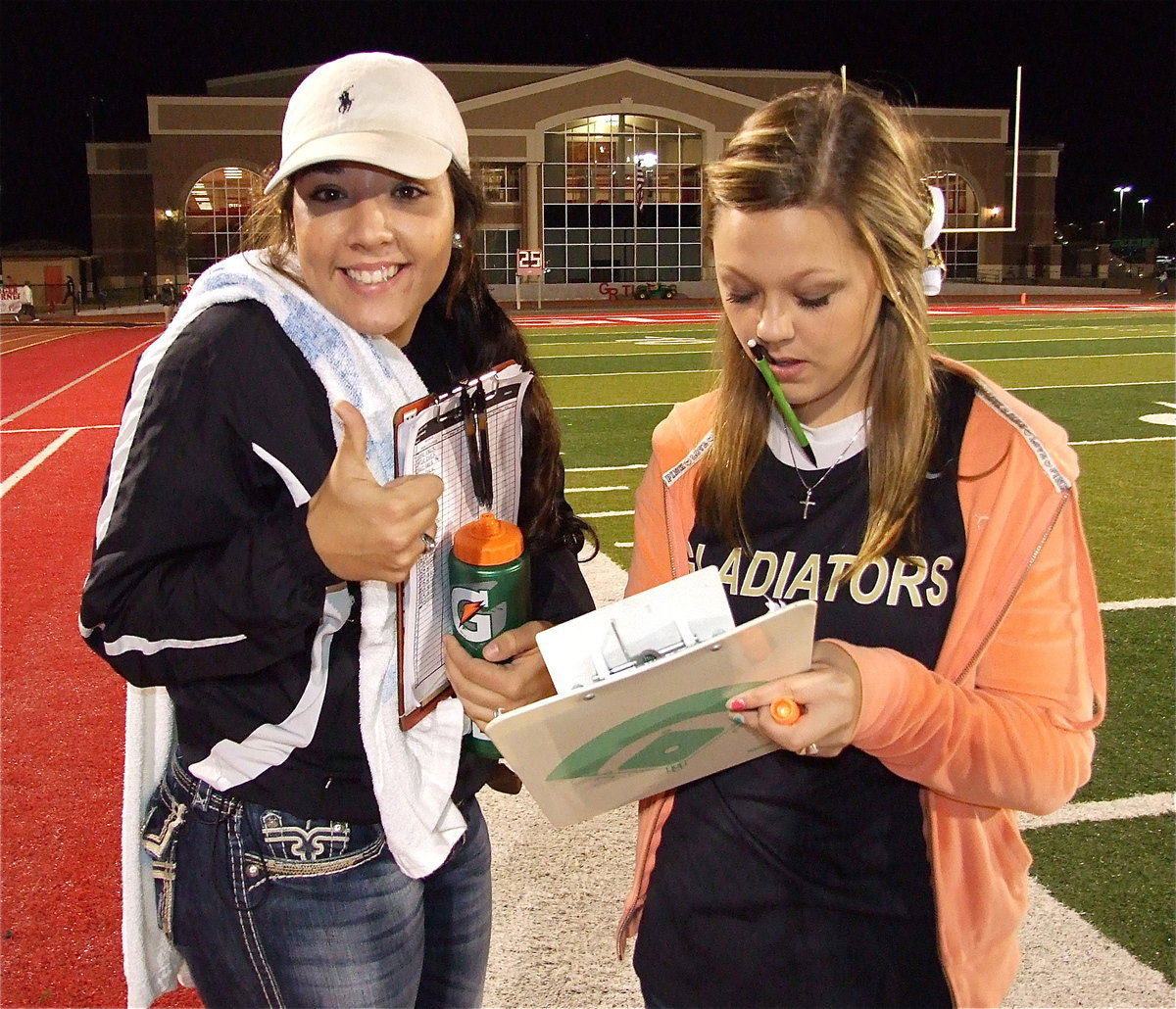 Image: Alyssa Richards and Bailey Eubank doing whatever it takes to help their guys weather its a towel, water, keeping the stats are just a pleasant smile.