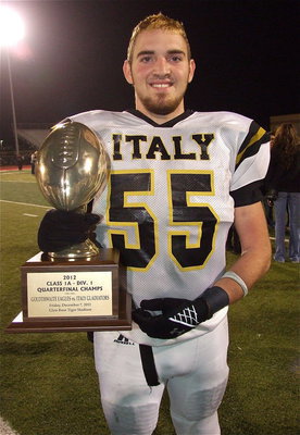 Image: Zackery Boykin(55) poses with the Italy’s quarterfinal championship trophy.