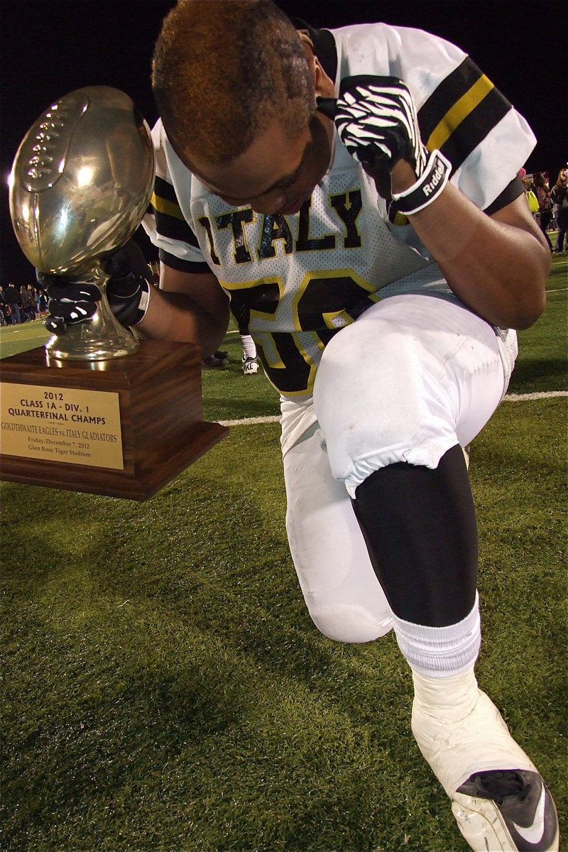 Image: From The Thinker to the The Tebo® and now The Gladiator as junior Darol Mayberry(58) strikes a pose with the quarterfinal championship trophy.