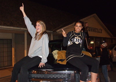 Image: Hannah Washington and Ashlyn Jacinto welcome back their team as the busses cruise thru downtown with lights flashing and horns blaring.
