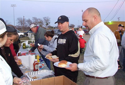 Image: Coach Josh Ward and Italy High School principal Lee Joffre take their turn in line for burgers.