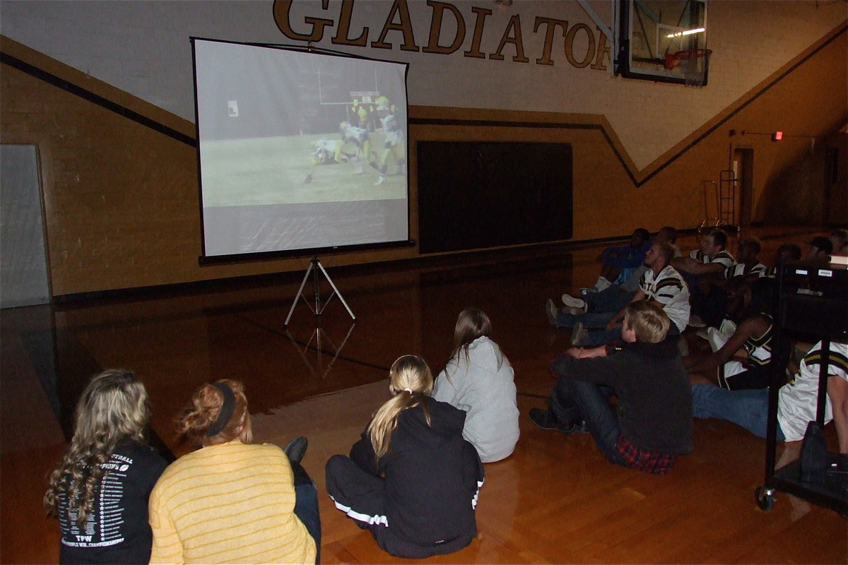 Image: Seniors sit on the floor to watch an inspirational video capturing memories from the football season thus far.