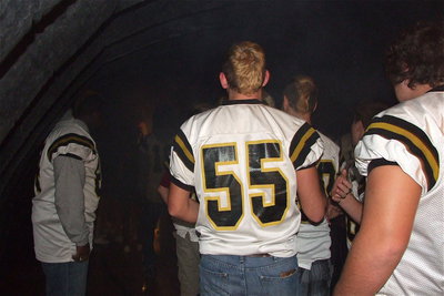 Image: Senior Gladiator Zackery Boykin(55), and his teammates prepare to emerge from the smoke filled tunnel.
