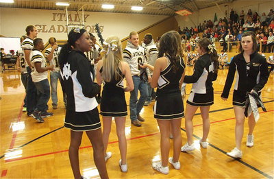 Image: The cheerleaders prepare to mask senior Gladiator Hayden Woods(8) for his turn at the football piñata.
