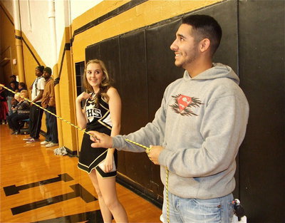 Image: Michael Martinez works the piñata as cheerleader Kelsey Nelson enjoys the comedic scene created by the festive idea.